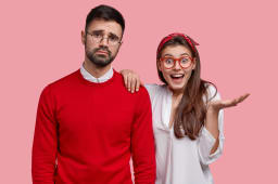 Une femme lve la paume, la main sur l'paule d'un homme qui a une expression triste.