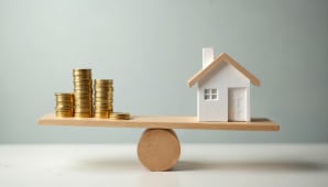 Une balance avec une maison et des piles de pices.