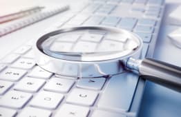 Loupe pose sur un clavier d'ordinateur, recherche de dtails.