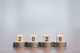 Des pices empiles soutenant des blocs de bois montrant '2026', concept de croissance financire et de planification future