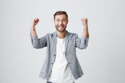 Heureux homme chanceux et ravi avec de la barbe dans des vtements  la mode, il serre les poings, se rjouit de son triomphe au travail, heureux de recevoir des bnfices levs, a sa propre entreprise prospre. Beau gars qui atteint ses objectifs.
