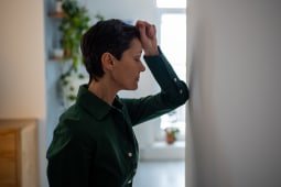 Une femme s'appuyant sur un mur.