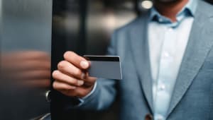 Gros plan d'un homme tenant une carte de crdit dans un ascenseur