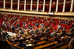 Parlementaires runis dans une salle orne pour une sance.