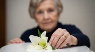 Femme ge en deuil, dposant un lys blanc, exprimant sa tristesse pour les funrailles et le souvenir.