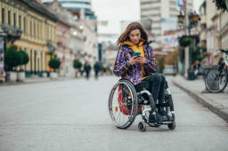 Femme handicap�e utilisant un smartphone en ville
