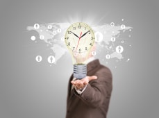 Un homme d'affaires en costume tient une ampoule avec une horloge