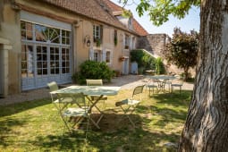 Cour int�rieure avec tables vertes devant maison traditionnelle fran�aise.