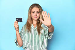 Femme tenant une carte et faisant un geste de refus.