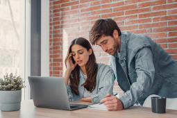 Un couple de millennials regardant leur ordinateur.