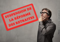 Homme rflchit devant panneau Suspension de la rforme des retraites.