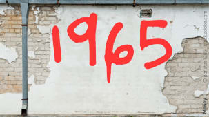 Numro 1965 rouge sur mur blanc caill et fissur. 1965