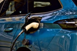 Une Peugeot 308 III hybride en charge dans la rue.