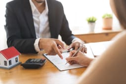 Deux personnes signent un contrat pour une maison.