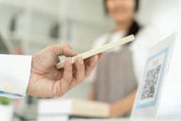 Les clients utilisent des smartphones pour scanner les codes QR afin de payer en magasin avec des paiements num�riques sans esp�ces