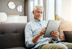 Personne �g�e, tablette et retraite � la maison pour taper des emails, communiquer et lire des nouvelles en ligne. Personne �g�e, technologie et d�tente sur le canap� dans le salon pour le paiement des factures, la vid�o et la lecture d'ebook