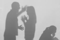 Silhouettes de parents se disputant et d'un enfant sur fond blanc.