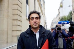 Homme avec dossier rouge interview� par des journalistes en ext�rieur.