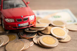 Des pi&egrave;ces de monnaie et une voiture miniature.