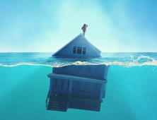 Une maison sous l'eau, avec quelqu'un sur son toit
