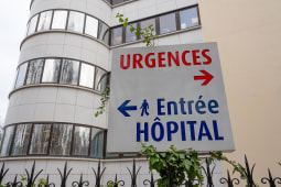 Un panneau avec URGENCES &eacute;crit en rouge et Entr&eacute;e h&ocirc;pital en bleu.