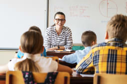 Une enseignante devant des enfants, en classe.
