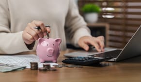 Une femme calcule ses imp�ts, y compris en d�posant des pi�ces dans une tirelire, �conomisant de l'argent, planifiant, investissant, budg�tisant, �conomisant de l'argent et assurant la croissance financi�re pour l'avenir.