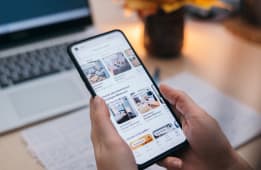 Personne cherchant un logement sur une application mobile, ordinateur derri�re.