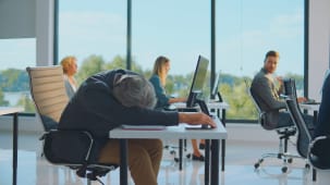 Un homme d'affaires stress&eacute; dans un open space.