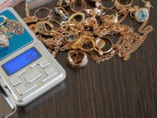 Bijoux en or pes&eacute;s sur une balance &eacute;lectronique digitale.