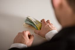 Un homme saisit des billets de banque.