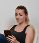 jeune femme &eacute;motionnelle au t&eacute;l&eacute;phone portable smartphone mimique effray&eacute;e