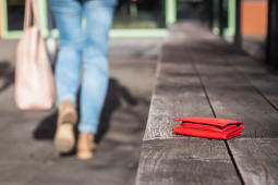 Une femme part d'un banc o&ugrave; elle a oubli&eacute; son portefeuille.