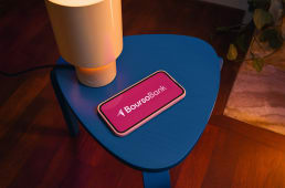 T�l�phone affichant BoursoBank sur une table bleue, lampe allum�e.