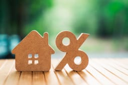 Concept de taux d'int�r�t immobilier avec mod�le de maison en bois et signe de pourcentage sur une table en bois. Hypoth�que, pr�t, taxe fonci�re et croissance des investissements sur le march� du logement. Image commerciale de stock.