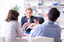 Une femme fait face &agrave; un homme et une femme, en pleine discussion