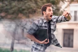 Un jeune homme en retard, regardant l'heure sur sa montre.