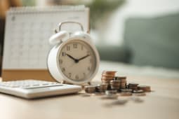 Un r&eacute;veil, des pi&egrave;ces de monnaie, une calculatrice et un calendrier.