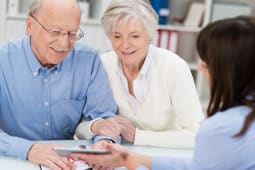 Un couple &acirc;g&eacute; consulte une femme pour des conseils.