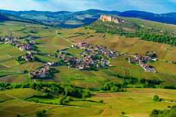Village entour&eacute; de vignobles et collines verdoyantes sous le soleil. Pouilly Solutre