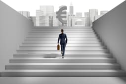 Un homme en costume monte un escalier avec le symbole de l'euro en haut.