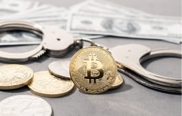 Concept de fraude li�e � la cryptomonnaie. Bitcoin et cryptomonnaies, menottes et billets de banque am�ricains.