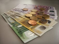 Billets et pi&egrave;ces en euros pos&eacute;s sur une table.