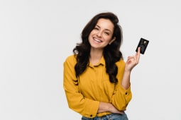 Belle jeune fille �tudiante hispanique latine tenant et pr�sentant une carte bancaire de cr�dit pour un paiement en ligne isol� sur fond blanc. Concept de technologie bancaire de magasinage en ligne