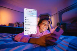 Femme souriante utilise une application bancaire sur son smartphone.