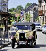 Vieille voiture jaune roule dans une rue de village fran�ais. Barbizon