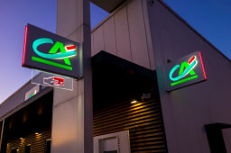 les logos en neon illumin�s de la banque fran�aise du Credit Agricole sur une agence bancaire