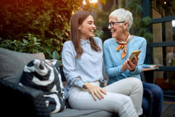 m&egrave;re montrant son t&eacute;l&eacute;phone portable &agrave; une fille, souriant et riant