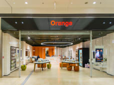 Boutique Orange moderne, produits &eacute;lectroniques expos&eacute;s, ambiance lumineuse et accueillante.