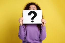 Femme afro-am&eacute;ricaine avec un signe de point d'interrogation sur fond jaune